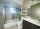 Clean bathroom featuring a shower-tub combo, modern vanity, and practical shelving for storage at 5690 W 79Th Ave, Arvada, CO 80003