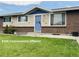 Charming single-story home with a brick facade, blue door, manicured lawn, and decorative butterfly accents at 5690 W 79Th Ave, Arvada, CO 80003