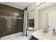 Bathroom featuring dark tiled shower over tub, with chrome fixtures and light vanity at 2408 Irving St, Denver, CO 80211