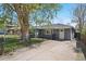 Charming single-story home featuring a well-maintained lawn, black fence, and mature tree providing ample shade at 2408 Irving St, Denver, CO 80211