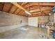 Spacious garage with exposed wood beams, a brick wall and concrete floors offering plenty of storage at 2408 Irving St, Denver, CO 80211