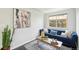 Cozy living room featuring a blue sofa, stylish decor, and a large window for natural light at 2408 Irving St, Denver, CO 80211