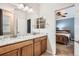 Bathroom with dual sinks, granite counters, and a view to the bedroom at 25561 E 5Th Pl, Aurora, CO 80018