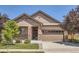 Inviting single-story home showcasing a well-manicured lawn, a two-car garage and attractive stone accents at 25561 E 5Th Pl, Aurora, CO 80018