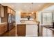 Bright kitchen features a large island with seating, granite countertops, stainless appliances, and hardwood floors at 25561 E 5Th Pl, Aurora, CO 80018