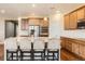 Bright kitchen with large island, seating, stainless appliances, wood cabinets and hardwood floors at 25561 E 5Th Pl, Aurora, CO 80018
