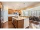 Bright kitchen features a large island with seating, stainless appliances, wood cabinets and hardwood floors at 25561 E 5Th Pl, Aurora, CO 80018