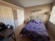 Cozy bedroom featuring a queen bed with purple comforter and matching pillows at 6887 S Dover Way, Littleton, CO 80128