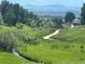 Picturesque walking path through lush green meadows, trees and mountains on the horizon at 6887 S Dover Way, Littleton, CO 80128