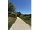 Picturesque walking path through lush green spaces with a grassy verge and homes in the background at 6887 S Dover Way, Littleton, CO 80128