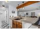 Bright kitchen with a breakfast bar, wood cabinets, and black and white checkered floor at 4899 S Dudley St # 3A, Littleton, CO 80123