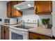 Kitchen featuring white appliances, wood cabinets, and neutral countertops at 4899 S Dudley St # 3A, Littleton, CO 80123