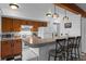 Kitchen with breakfast bar, wood cabinetry, and washer/dryer with ample countertop space at 4899 S Dudley St # 3A, Littleton, CO 80123