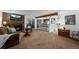 Cozy living room featuring a brick fireplace, plush carpet, and open access to the kitchen bar at 4899 S Dudley St # 3A, Littleton, CO 80123