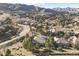 Scenic aerial view of a neighborhood nestled amongst trees and rolling hills, offering stunning mountain vistas at 6960 Choke Cherry Way, Littleton, CO 80125