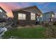 Well-maintained backyard featuring artificial grass, a patio area, and neutral colored siding at 6956 S Titus St, Aurora, CO 80016