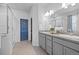 Modern bathroom featuring double sinks, gray cabinets, and a glass-enclosed shower at 6956 S Titus St, Aurora, CO 80016