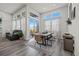 Bright dining area with large windows, modern furnishings, and an open layout to the living room at 6956 S Titus St, Aurora, CO 80016