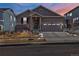 Charming home featuring a two-car garage, neutral-colored siding, and well-maintained landscaping at 6956 S Titus St, Aurora, CO 80016