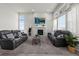 Bright living room with a cozy fireplace, large windows, and comfortable leather sofas at 6956 S Titus St, Aurora, CO 80016