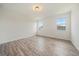 Bedroom featuring wood-look floors, two windows, and neutral-colored walls at 26789 E Cedar Ave, Aurora, CO 80018