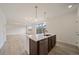 Kitchen island with a stainless steel dishwasher and sink offers lots of counter space and stylish pendant lighting at 26789 E Cedar Ave, Aurora, CO 80018