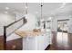 Bright, open-concept kitchen featuring a granite island, white cabinetry, and dark wood floors at 19543 E 54Th Ave, Denver, CO 80249