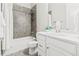 Modern bathroom with gray tile shower and vanity with white countertops at 17720 W 94Th Dr, Arvada, CO 80007