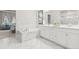 Bright bathroom with marble tile, soaking tub and dual sink vanity at 17720 W 94Th Dr, Arvada, CO 80007
