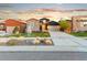 Charming home boasts stone and dark siding accents, complemented by a well-manicured front yard under a beautiful sunset sky at 17720 W 94Th Dr, Arvada, CO 80007
