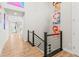 Hallway with modern railings leads to a living area, adorned with colorful art for a contemporary feel and style at 17720 W 94Th Dr, Arvada, CO 80007