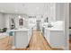 Spacious kitchen featuring a large island, white cabinets, stainless steel appliances, and an open layout to the dining area at 17720 W 94Th Dr, Arvada, CO 80007