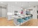 Modern kitchen island with quartz countertops, stainless steel appliances, and stylish bar stools at 17720 W 94Th Dr, Arvada, CO 80007