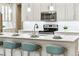 Kitchen island features quartz countertops, stainless steel appliances, and breakfast bar seating at 17720 W 94Th Dr, Arvada, CO 80007