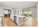 Open-concept kitchen featuring a large island, stainless steel appliances, and a view into the living room and outdoor space at 17720 W 94Th Dr, Arvada, CO 80007
