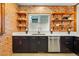 Kitchen features stainless appliances, dark wood cabinets, white quartz countertops, and exposed brick wall at 3928 Zuni St, Denver, CO 80211