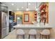 Renovated kitchen boasts stainless steel appliances, quartz countertop, and exposed brick accent wall with floating shelves at 3928 Zuni St, Denver, CO 80211