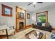 Bright living room featuring an exposed brick fireplace, wood trim, and large windows at 3928 Zuni St, Denver, CO 80211