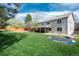Spacious backyard featuring a covered patio, lush green lawn, and mature trees for outdoor enjoyment at 9325 Lark Sparrow Dr, Highlands Ranch, CO 80126