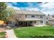 Spacious backyard featuring a covered patio area, mature trees, and a well-manicured lawn at 9325 Lark Sparrow Dr, Highlands Ranch, CO 80126