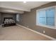 Finished basement bedroom space with a plaid comforter, a large window, and carpeted floors at 9325 Lark Sparrow Dr, Highlands Ranch, CO 80126