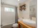 This bathroom features open shelving, white subway tile and shower, a new commode, and a contemporary sink at 9325 Lark Sparrow Dr, Highlands Ranch, CO 80126