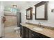 Bathroom featuring double sinks, wood cabinets, tile backsplash, and tub with tiled wall and shower at 9325 Lark Sparrow Dr, Highlands Ranch, CO 80126
