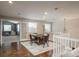 Bright bonus room featuring wood floors, a central chandelier, a round table, and an adjacent play area at 9325 Lark Sparrow Dr, Highlands Ranch, CO 80126