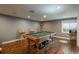 Game room with a pool table, bar stools, hardwood floors, overhead lights, and neutral colored walls at 9325 Lark Sparrow Dr, Highlands Ranch, CO 80126