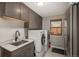 Well-equipped laundry room with modern washer and dryer, ample storage, and a utility sink at 9325 Lark Sparrow Dr, Highlands Ranch, CO 80126
