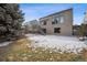 Large backyard with mature trees and a view of the home's exterior, showcasing multiple windows at 1711 Spring Water Ln, Highlands Ranch, CO 80129