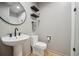 Contemporary bathroom featuring a pedestal sink, modern toilet, and floating shelves at 1711 Spring Water Ln, Highlands Ranch, CO 80129