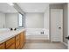 Bathroom with a large soaking tub, double vanity, and a large mirror at 1711 Spring Water Ln, Highlands Ranch, CO 80129