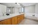 Bright bathroom with a soaking tub, double sink vanity, and tiled floors at 1711 Spring Water Ln, Highlands Ranch, CO 80129